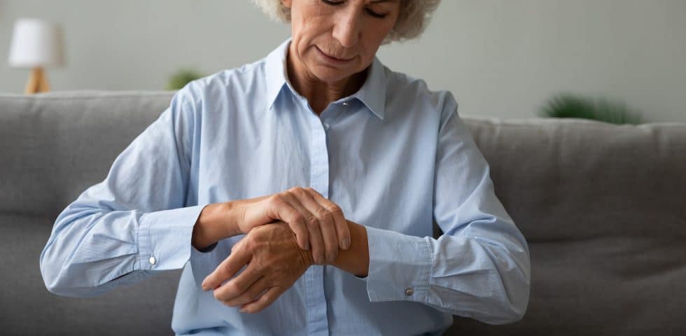 A woman massages her wrists, chronically inflamed from Lyme Disease